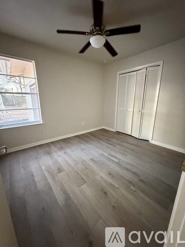A room with a ceiling fan and sliding doors.