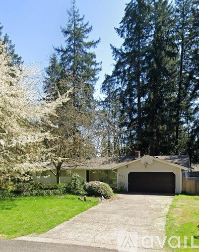 A house with a garage and a driveway in front of it.