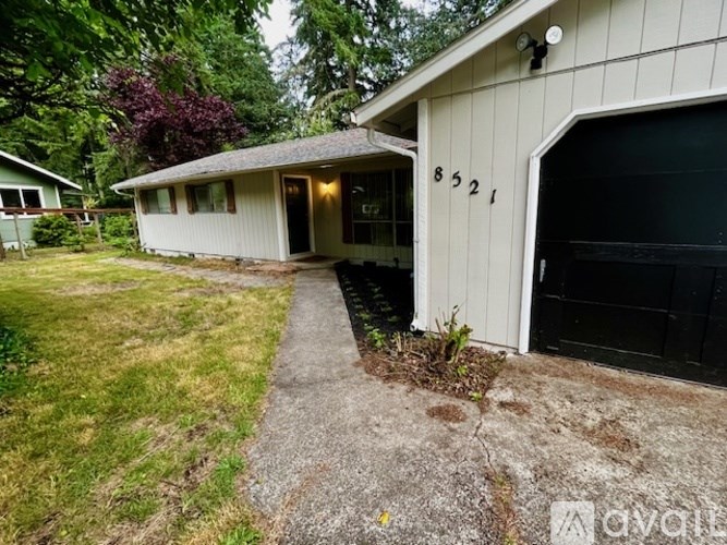 A house numbered 8521 with a driveway leading to the garage.