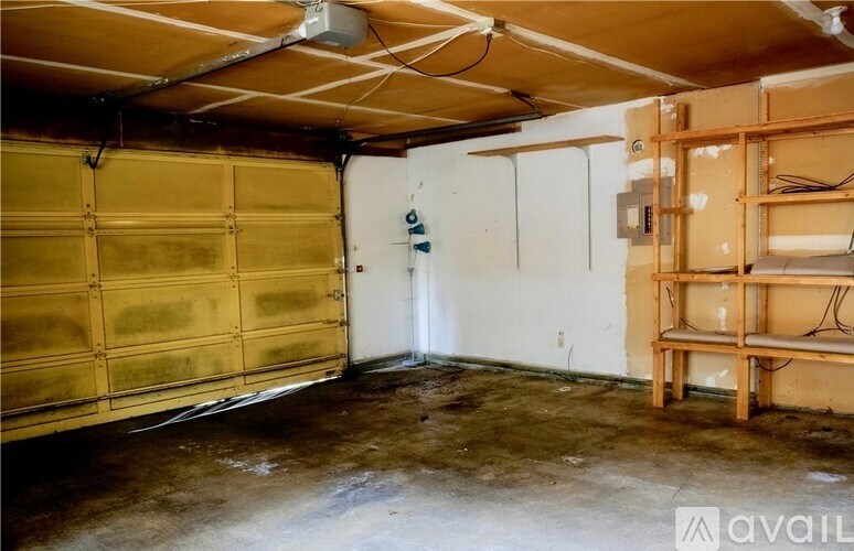 A room with a white door and a white wall with a fan on the ceiling.