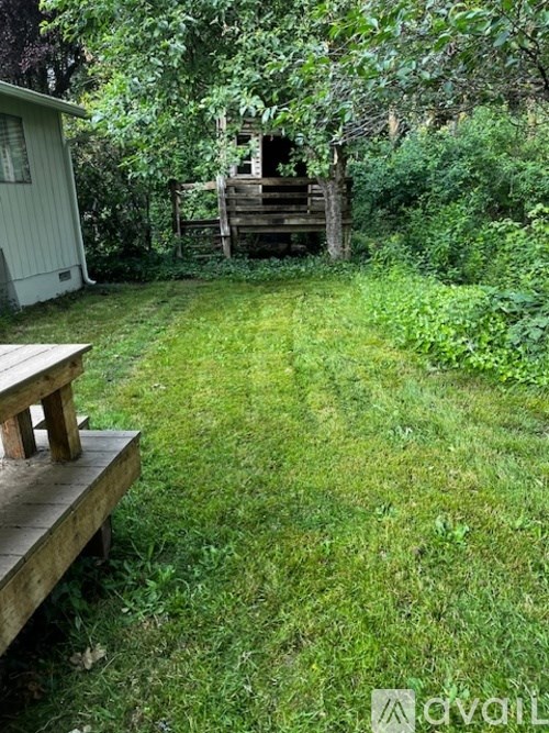 A backyard with a wooden deck and a shed.
