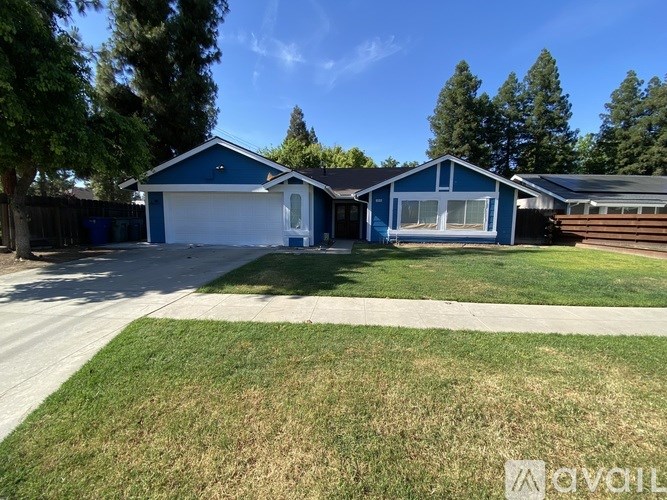A blue house with a white garage door and a brown fence.