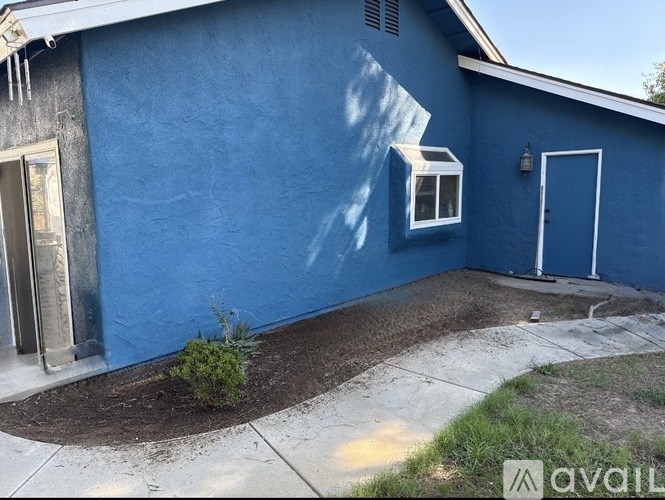 A blue house with a white door and window.
