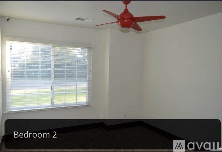 Bedroom 2 has a window with blinds and a red ceiling fan.