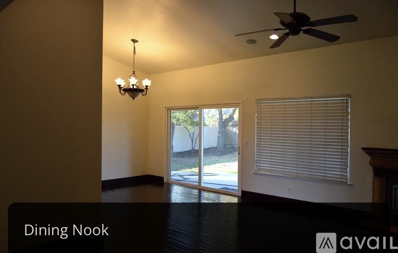 A dining nook with a ceiling fan and a chandelier.