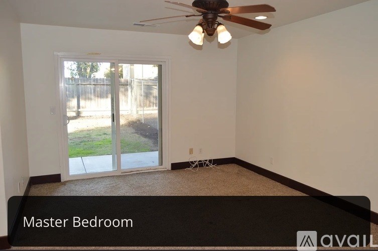 A master bedroom with a ceiling fan and sliding glass doors.