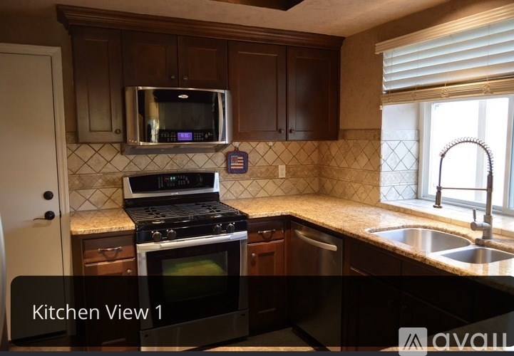 A kitchen with a black stove top oven and a microwave above it.