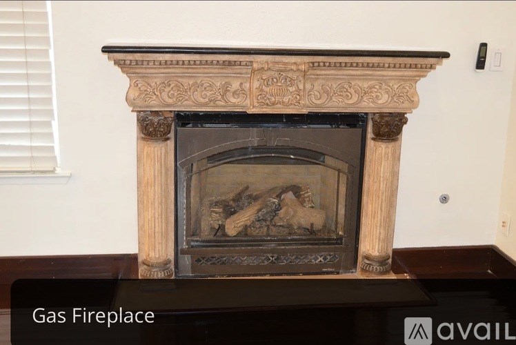 A fireplace with a marble mantle and a fire burning inside.