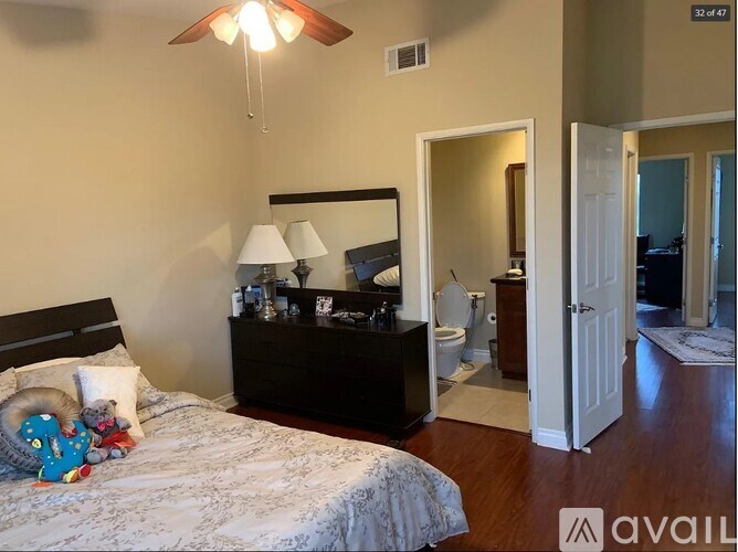 A bedroom with a bed, nightstand, and a ceiling fan.
