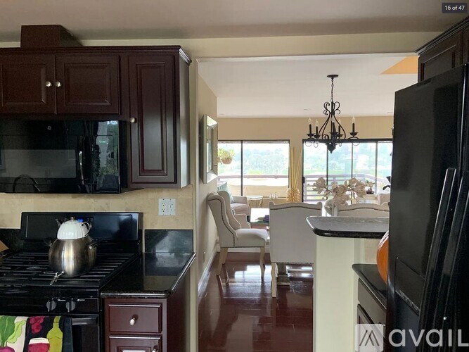 A kitchen with dark brown cabinets and a black stove top.