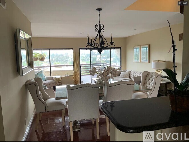 A living room with a chandelier, sofas, and a dining table.