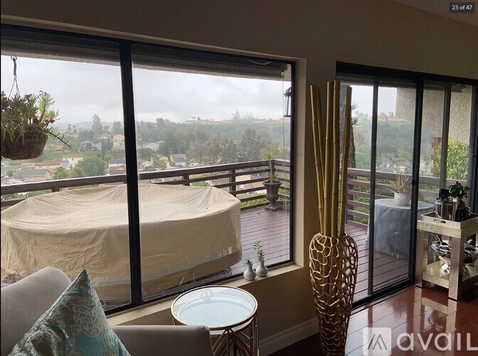 A balcony with a table and chairs overlooking a covered patio.