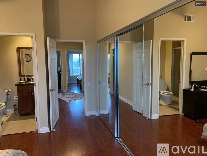 A bathroom with a toilet, sink, and mirror.