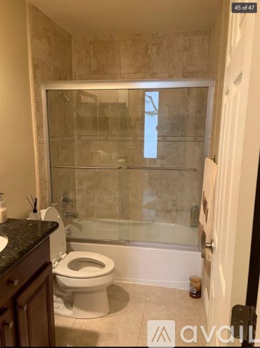 A bathroom with a toilet, sink, and shower.