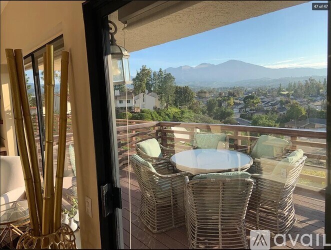 A balcony with a table and chairs overlooking a mountain.