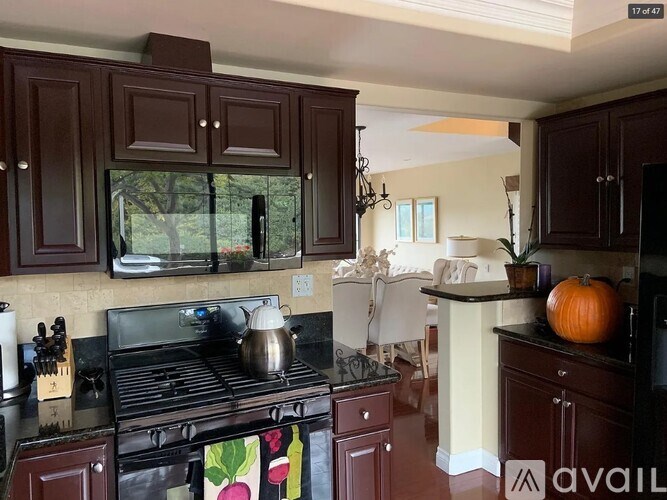 A kitchen with dark wood cabinets and a black stove top.
