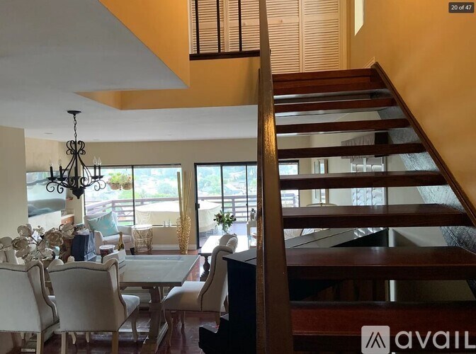 A living room with a dining table and chairs and a staircase.