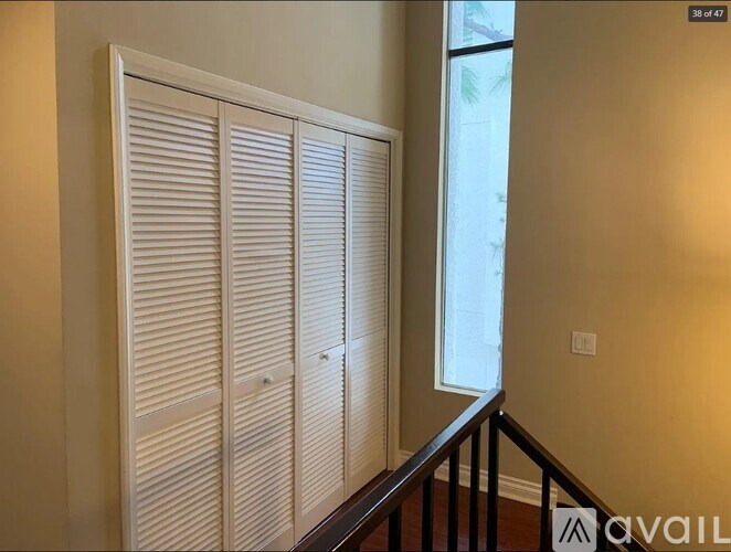 Closed white blinds on a window in a room.