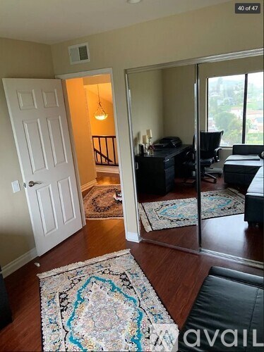 A living room with a rug on the floor and a doorway leading to another room.