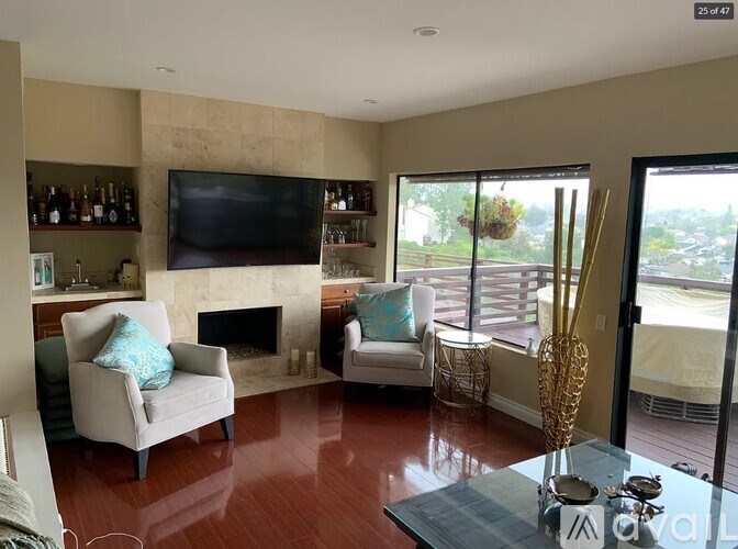 A living room with a fireplace and a flat screen TV mounted on the wall.