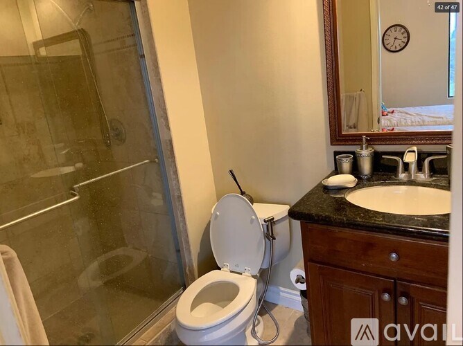 A bathroom with a toilet, sink, and mirror.