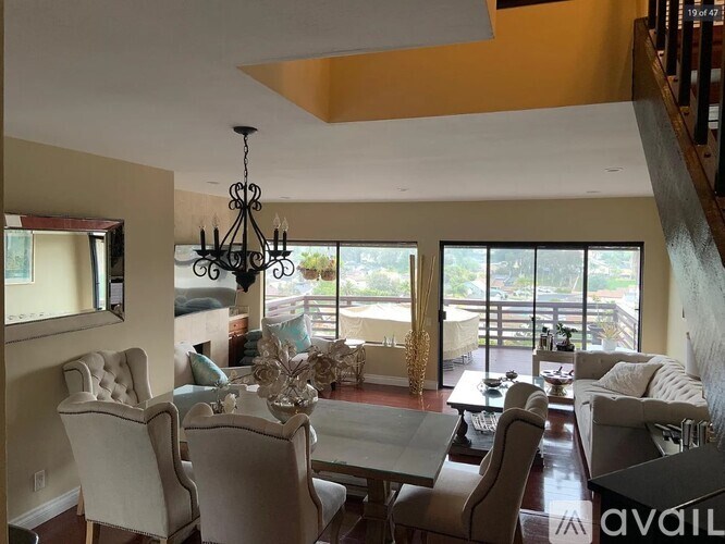 A dining room with a chandelier and a view of the backyard.