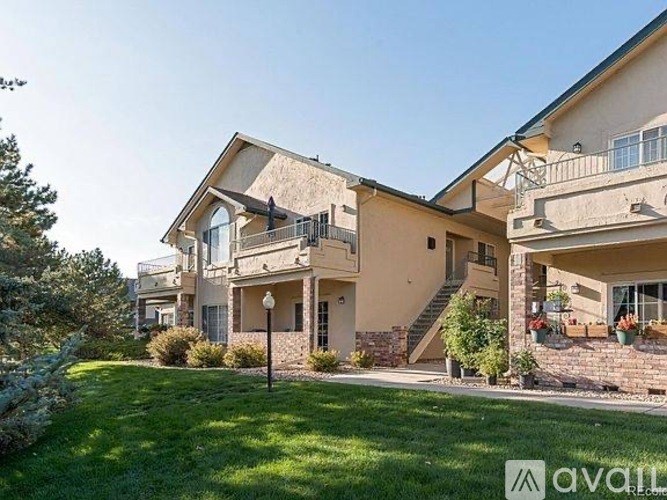 A large house with a balcony and a garden in front.