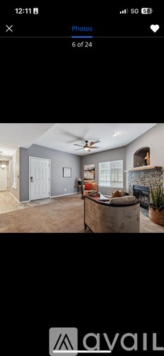 A room with a ceiling fan and a fireplace.