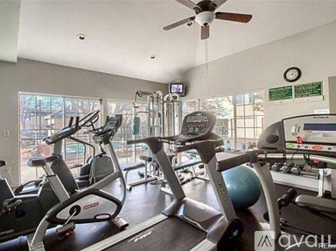 A gym with a treadmill, exercise bike and other equipment.