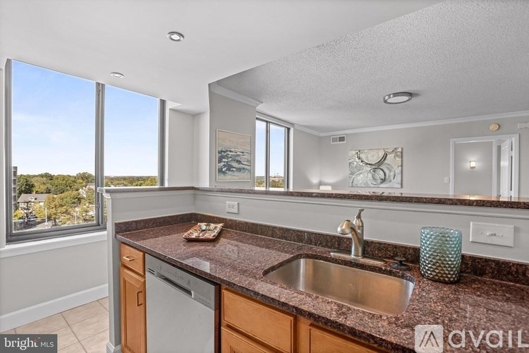 A kitchen with a brown granite countertop and a dishwasher.