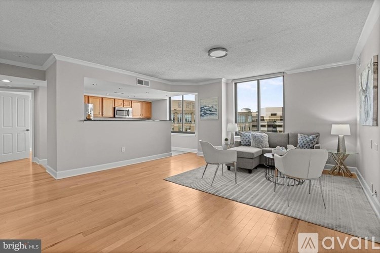 A living room with a grey couch and a grey rug.