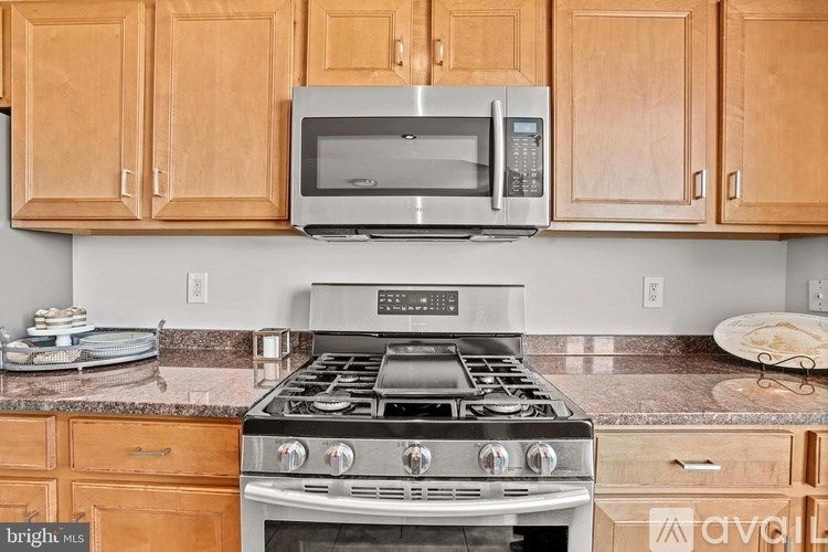 A kitchen with a stove top oven and microwave above it.