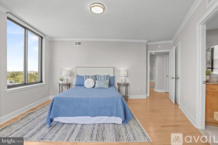 A bedroom with a bed, two lamps, and a window.