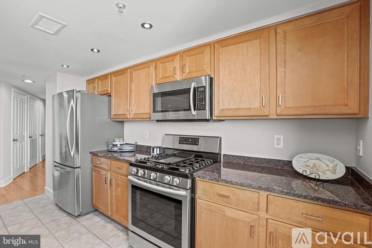 A kitchen with wooden cabinets and a stainless steel refrigerator.