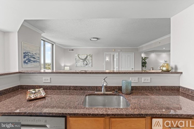 A kitchen with a marble countertop and a sink.