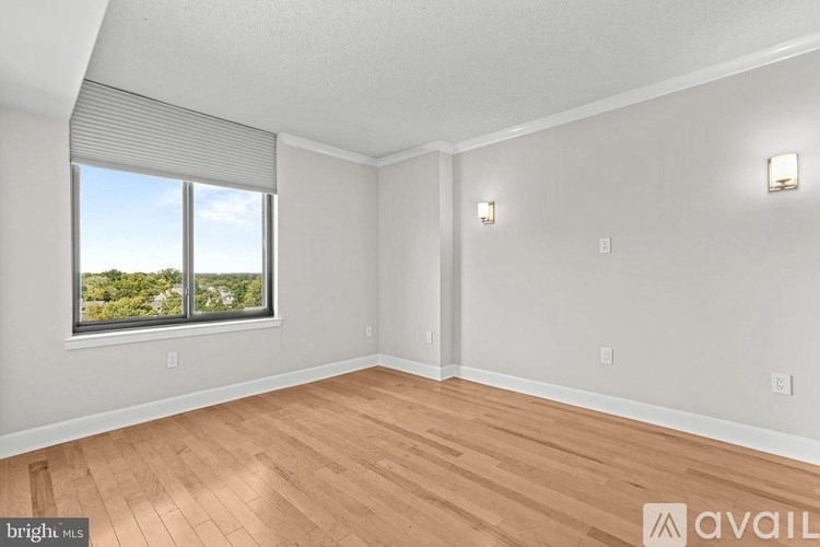 A room with wooden flooring and a window overlooking a landscape.