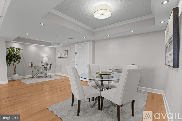 A modern dining room with a glass table and chairs.