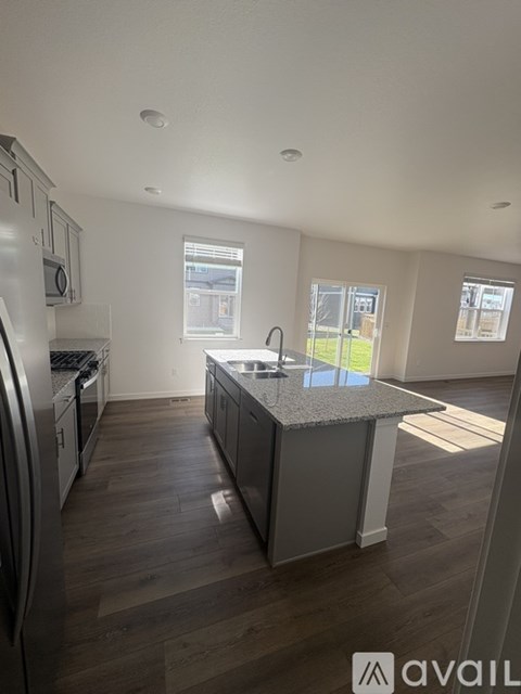 A kitchen with a granite countertop and stainless steel appliances.