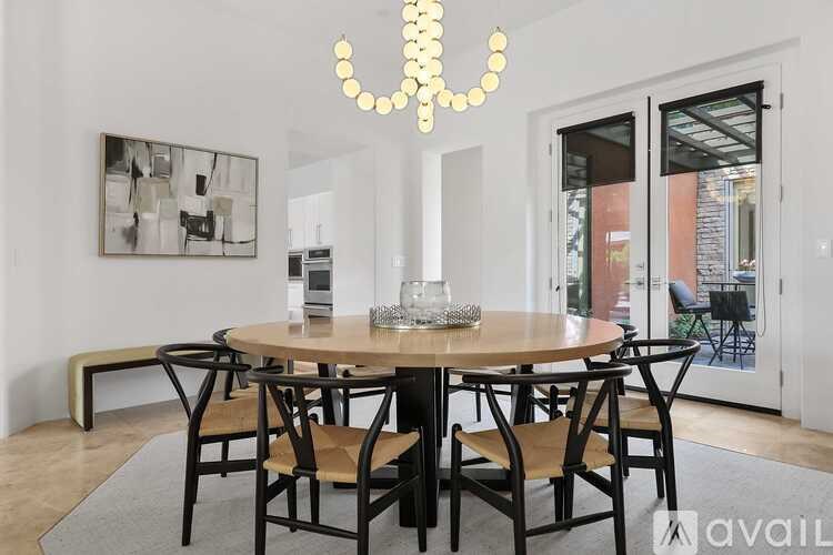 A modern dining room with a round table and chairs.