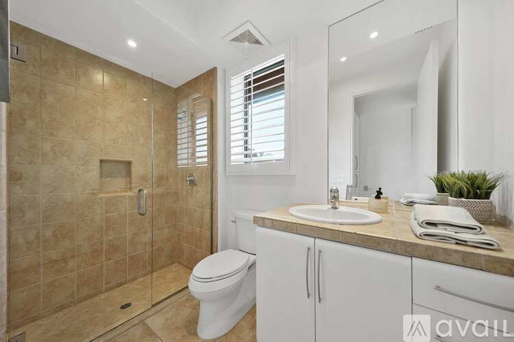 A bathroom with a toilet, sink, and shower.