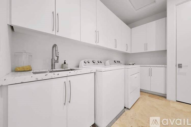 A white kitchen with a washing machine and a fridge.