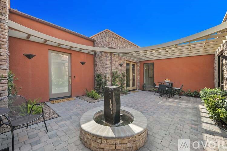 A patio with a table and chairs and a fountain.
