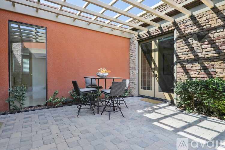 A patio with a table and chairs is covered by a roof.