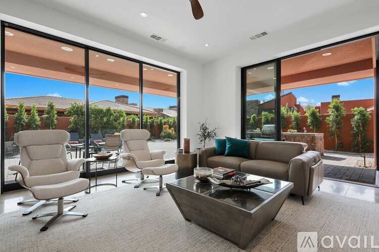 A living room with a large window and a view of a residential area.