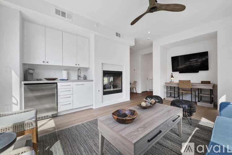 A modern kitchen with white cabinets and a grey island.