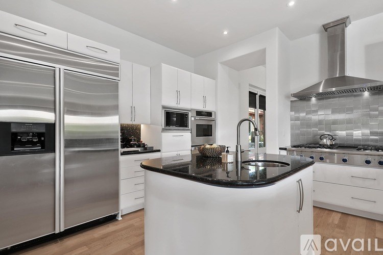 A modern kitchen with stainless steel appliances and white cabinetry.