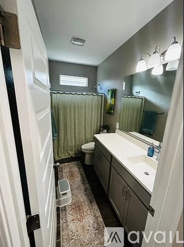 A bathroom with a toilet, sink, and shower.