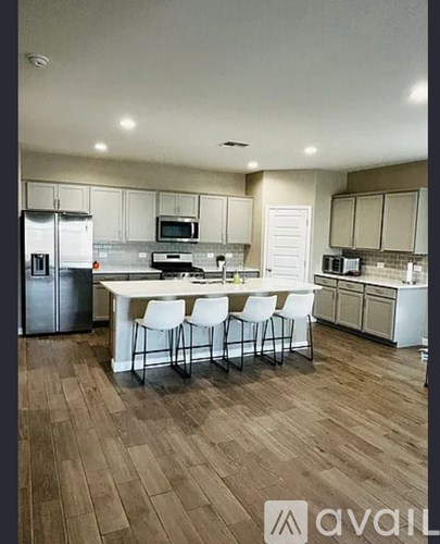 A kitchen with a white table and chairs in the middle of the room.