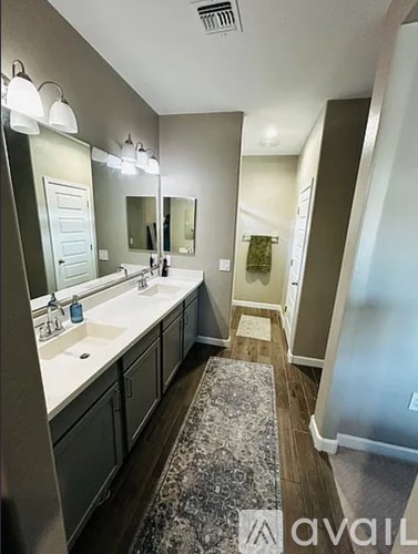 A bathroom with a sink, mirror, and rug.