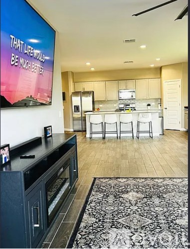 A kitchen with a black countertop and a fridge.